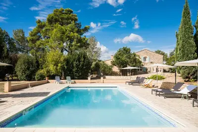 a swimming pool with chairs and a house at La closerie des iris in Castelnau-dʼAude