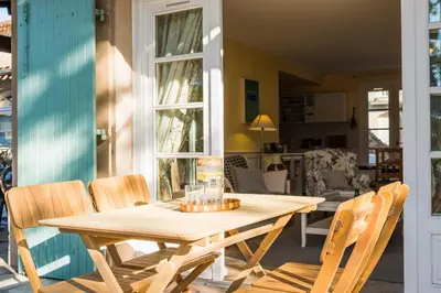 a wooden table and chairs on a patio at La closerie des iris in Castelnau-dʼAude