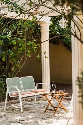 two chairs and a table with a bottle of wine at La closerie des iris in Castelnau-dʼAude