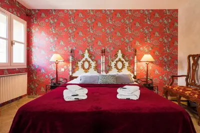 a red bedroom with a bed with red wallpaper at La closerie des iris in Castelnau-dʼAude