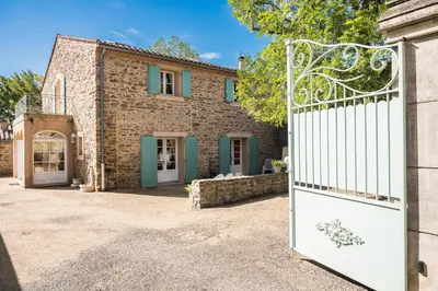 an entrance to a stone house with a gate at La closerie des iris in Castelnau-dʼAude