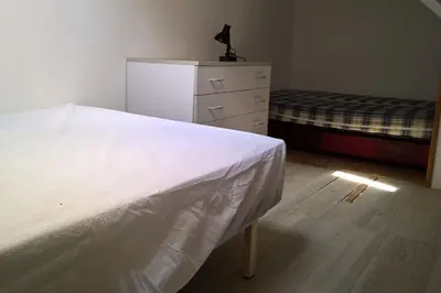 a bedroom with a white bed and a dresser at Pavillon in Port-la-Nouvelle