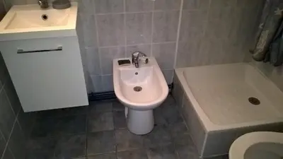 a bathroom with a bidet and a toilet and a sink at Pavillon in Port-la-Nouvelle