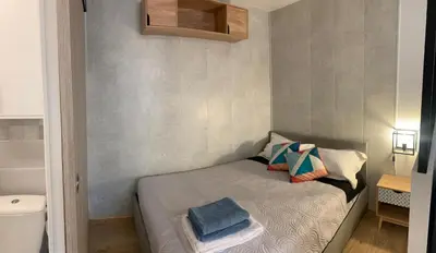 a small bedroom with a bed and a toilet at Appartement avec terrasse au cœur de Carcassonne - Serviettes Draps Ménage inclus in Carcassonne