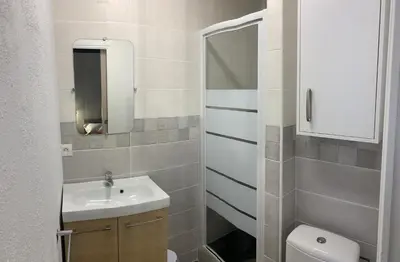 a bathroom with a sink and a toilet and a mirror at Appartement avec terrasse au cœur de Carcassonne - Serviettes Draps Ménage inclus in Carcassonne