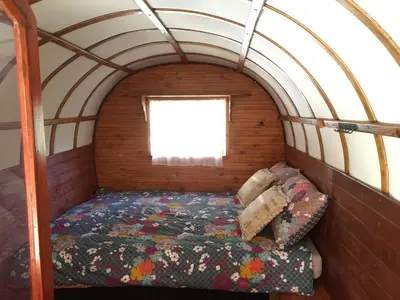 a bed in a small room with a window at Le Camping de Cucugnan in Cucugnan