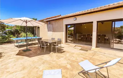 a patio with a table and chairs and an umbrella at Cozy Home In Saint-Jean-De-Minervoi in Saint-Jean-de-Minervois