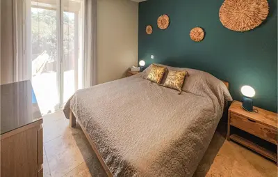 a bedroom with a bed and a green wall at Cozy Home In Saint-Jean-De-Minervoi in Saint-Jean-de-Minervois