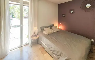 a bedroom with a bed and a large window at Cozy Home In Saint-Jean-De-Minervoi in Saint-Jean-de-Minervois