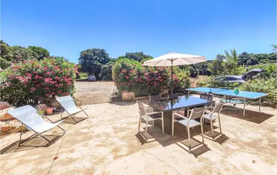 a patio with a table and chairs and an umbrella at Cozy Home In Saint-Jean-De-Minervoi in Saint-Jean-de-Minervois