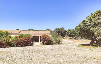a house with a lot of flowers in front of it at Cozy Home In Saint-Jean-De-Minervoi in Saint-Jean-de-Minervois