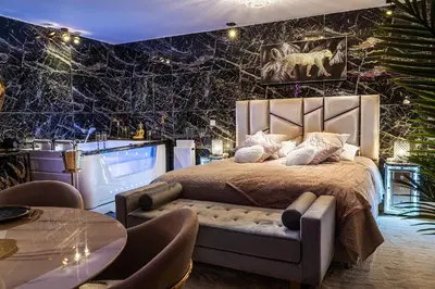 a bedroom with a bed and a table and chairs at Magnifique loft / spa en face de la cathédrale ! in Narbonne