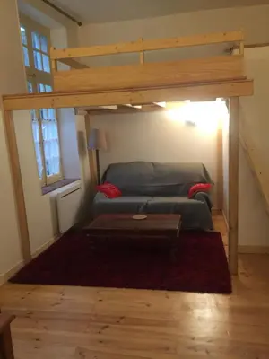 a living room with a couch and a loft bed at Cosy, calme et authentique au coeur de ville in Carcassonne