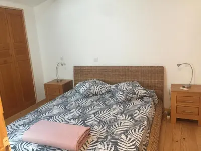 a bed with a black and white comforter in a bedroom at Cosy, calme et authentique au coeur de ville in Carcassonne