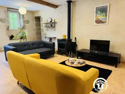 a living room with a yellow couch and a fireplace at Le cazal in Sainte-Eulalie