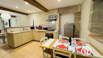 a kitchen with a table and a dining room at Le cazal in Sainte-Eulalie