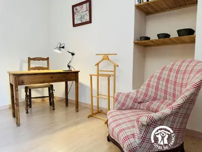 a living room with a chair and a desk at Le cazal in Sainte-Eulalie