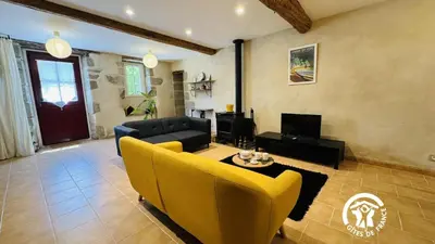a living room with yellow chairs and a couch at Le cazal in Sainte-Eulalie