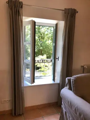 a window with curtains in a room with a couch at The Gatehouse in Castres
