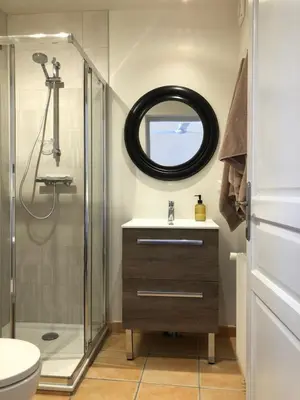 a bathroom with a shower and a sink and a mirror at The Gatehouse in Castres