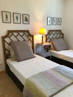 a bedroom with two beds and a table with a lamp at The Gatehouse in Castres