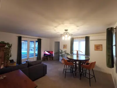 a living room with a couch and a table and chairs at Maison L'Inattendu avec spa & piscine privatifs in Moussan