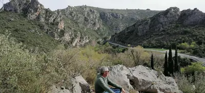 a man sitting on a rock on a mountain at Villa Ripaud Chambre d'Hôte in Villesèque-des-Corbières
