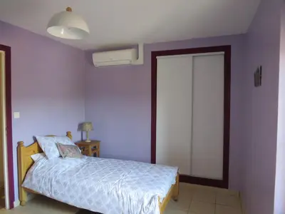 a bedroom with purple walls and a bed and a window at Villa Ripaud Chambre d'Hôte in Villesèque-des-Corbières