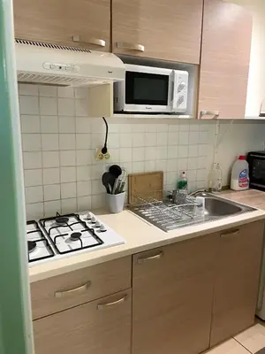 a kitchen with a stove and a sink and a microwave at Villa Ripaud Chambre d'Hôte in Villesèque-des-Corbières