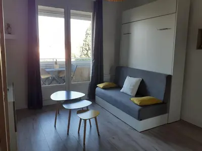 a living room with a couch and a table and a window at Studio Balcon Proche Hypercentre de Narbonne in Narbonne