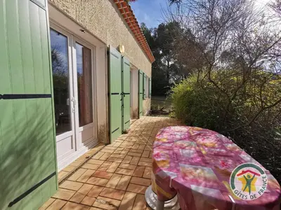 a patio with a table on the side of a building at Le janabel in Prades-sur-Vernazobre