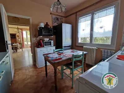a kitchen with a table and a small kitchen with a refrigerator at Le janabel in Prades-sur-Vernazobre