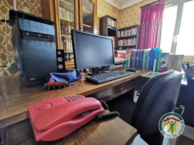a desk with a computer monitor and a keyboard at Le janabel in Prades-sur-Vernazobre