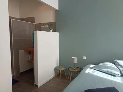 a bedroom with a bed and two stools at Jolie Maison au centre du village in Gruissan