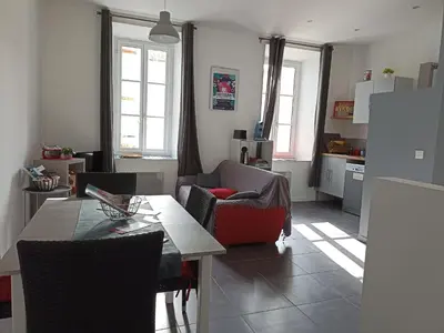 a kitchen and living room with a table and chairs at Jolie Maison au centre du village in Gruissan