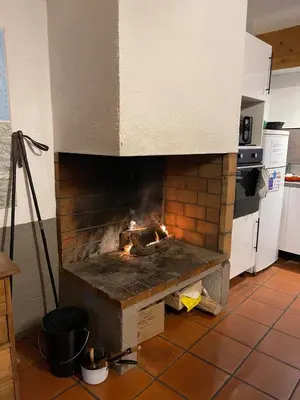 a kitchen with a brick oven with a fire in it at Gîte XL Familles et groupes Duilhac sous Peyrepertuse in Duilhac