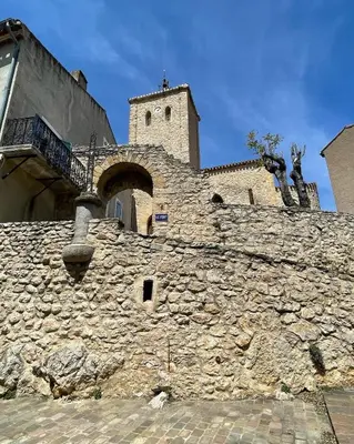 a stone building with a tower on top of it at Gîte XL Familles et groupes Duilhac sous Peyrepertuse in Duilhac