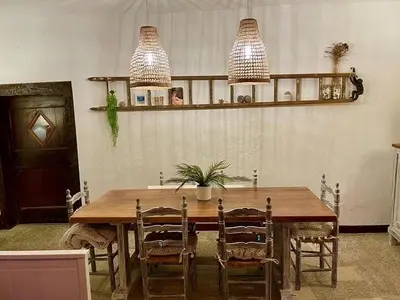 a dining room table with chairs and two pendant lights at Chez Luis et David in Avignonet-de-Lauragais
