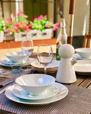 a wooden table with plates and wine glasses on it at Chez Luis et David in Avignonet-de-Lauragais