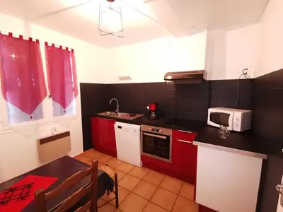 a small kitchen with red cabinets and a microwave at Desix in Trilla