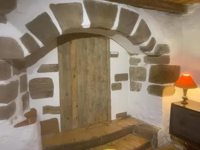 a room with a wooden door in a stone wall at Gîte de la Bastide - Cabania Pays Cathare in Camps-sur-lʼAgly