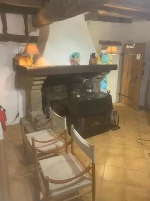 a living room with two chairs and a fireplace at Gîte de la Bastide - Cabania Pays Cathare in Camps-sur-lʼAgly