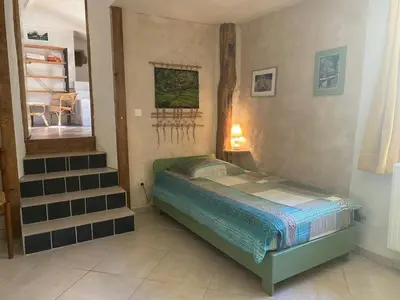a small bedroom with a bed and a staircase at Gîte de la Bastide - Cabania Pays Cathare in Camps-sur-lʼAgly