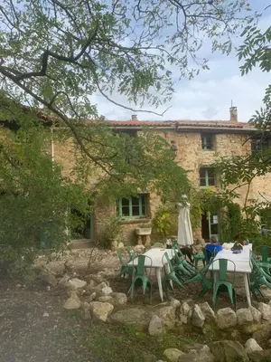 a stone house with tables and chairs in front of it at Gîte de la Bastide - Cabania Pays Cathare in Camps-sur-lʼAgly
