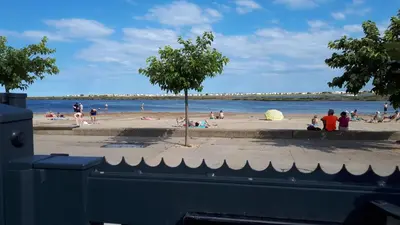 a group of people on a beach near the water at la playa in Gruissan