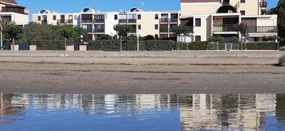 a reflection of buildings in a body of water at la playa in Gruissan