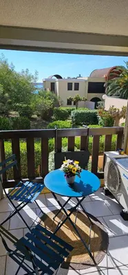 a blue table and chairs on a balcony at la playa in Gruissan