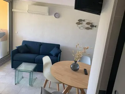 a living room with a blue couch and a table at la playa in Gruissan