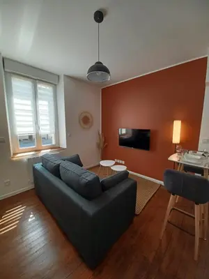 a living room with a couch and a table at Mazamet - Studio neuf et moderne en centre-ville in Mazamet
