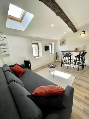 a living room with a gray couch and a table at NEW, La Passante, Belle vue in Conques-sur-Orbiel